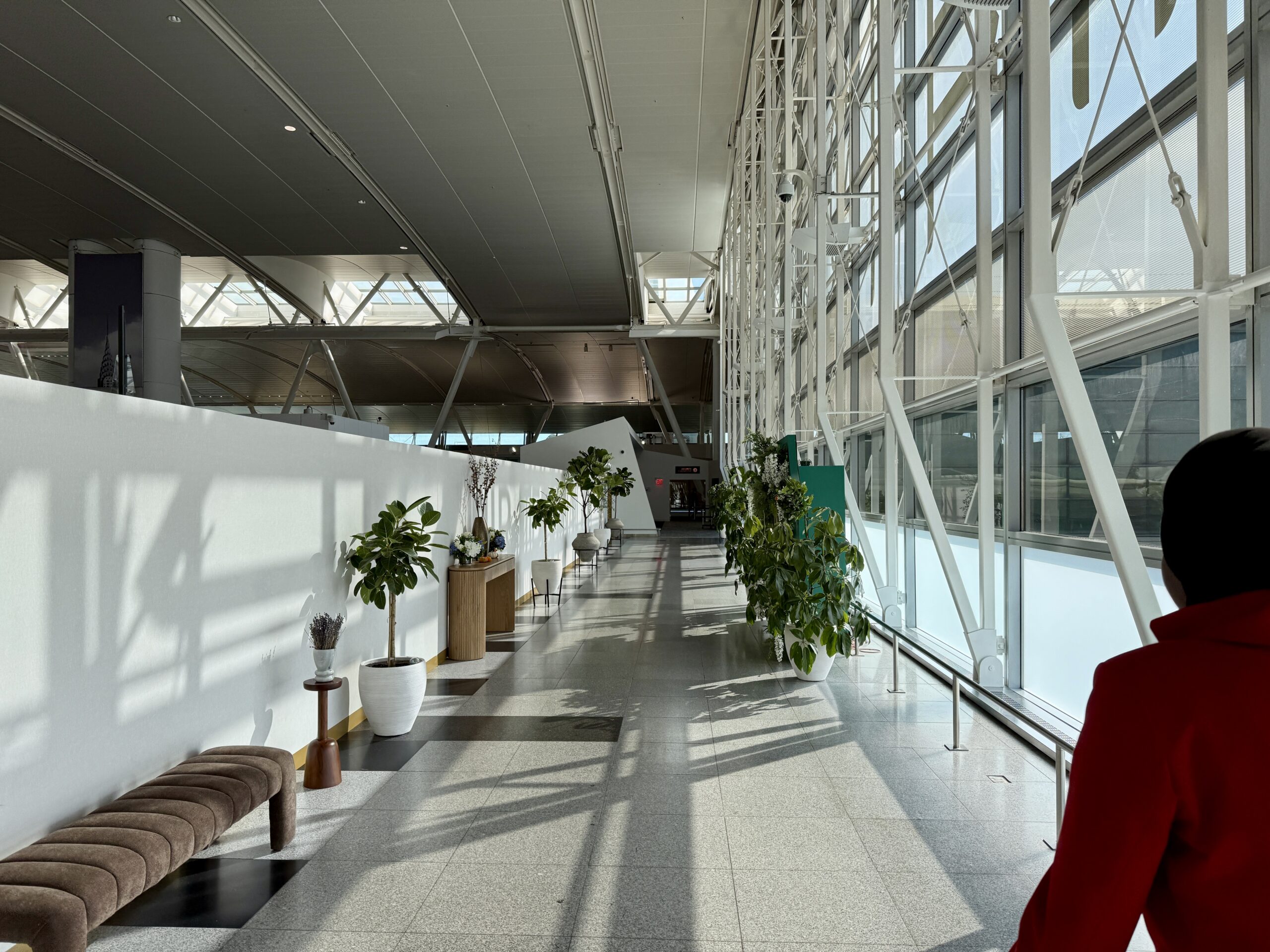 woman in red walking down corridor in an airport